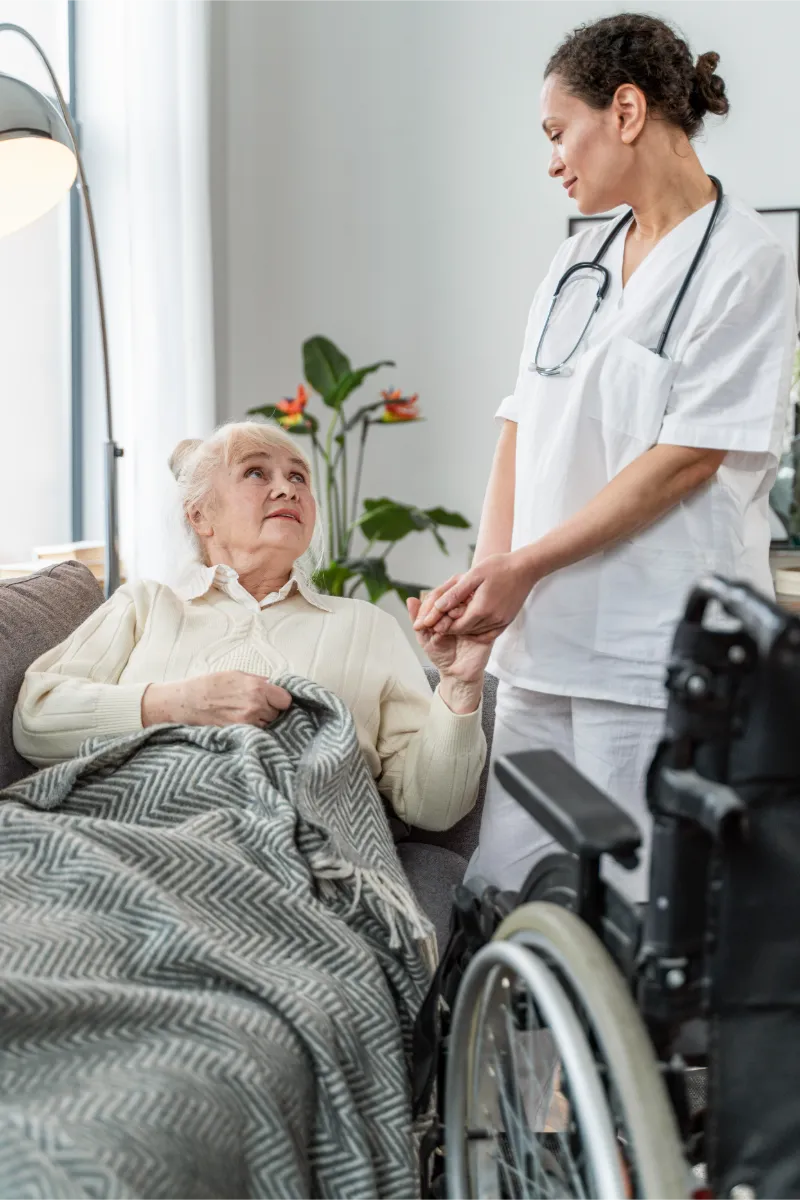 Ärztin spricht mit einer Seniorin zu Hause