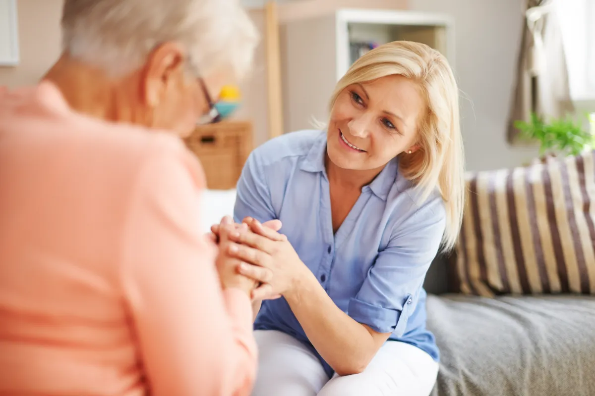 Pflegekraft im Gespräch mit einer Seniorin